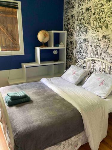 une chambre avec un lit avec un mur bleu dans l'établissement charment logement avec piscine et jardin, à Baurech