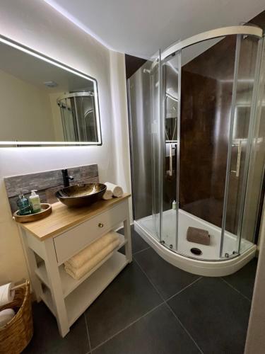 a bathroom with a shower and a sink and a mirror at Luxury Cottage in Tregarth, Bethesda, Snowdonia in Tregarth