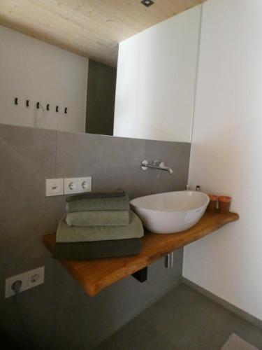 ein Badezimmer mit einem Waschbecken und einer Theke mit Handtüchern in der Unterkunft Stylische Fewo in Bestlage in neugebautem Holzhaus mit Oberstaufen Plus in Oberstaufen