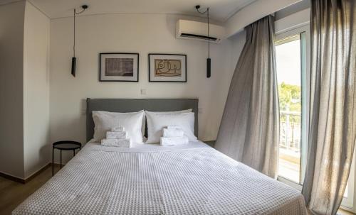 a bedroom with a bed with two pillows and a window at Zoe's cozy room 2 in Artemida