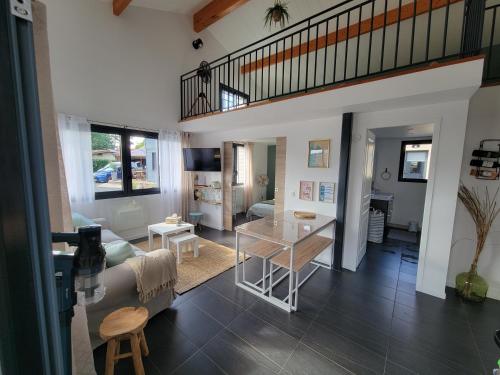 a living room with a table and a couch at Les Cabanes de l'Airial Ecume in Andernos-les-Bains