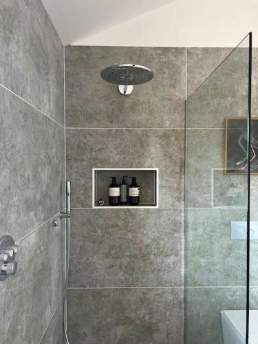 uma casa de banho com um chuveiro e uma porta de vidro em The guest House em Penrith