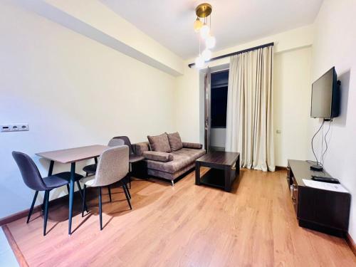 un salon avec une table et un canapé dans l'établissement Modern Apartment +Balcony next to Republic Square, City Center, à Erevan