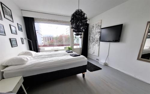 a bedroom with a bed and a flat screen tv at Central Gem with Sauna - Big two-room apartment FREE PARKING in Tampere