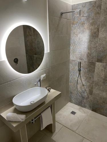 a bathroom with a sink and a shower with a mirror at Palazzo Matà Boutique Hotel in Taranto