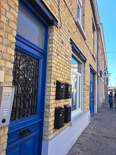 a building with a blue door on a street at appartement la Gravelinoise in Gravelines