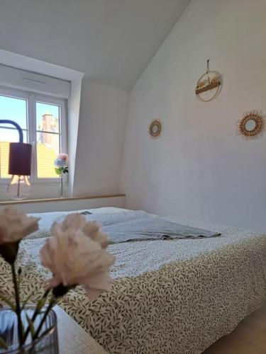 a white bedroom with a bed and a window at appartement la Gravelinoise in Gravelines