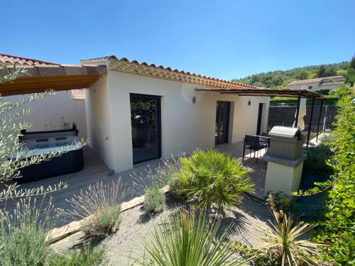 une maison blanche avec une terrasse ornée de plantes dans l'établissement Gite Saint Christophe, à Vaison-la-Romaine