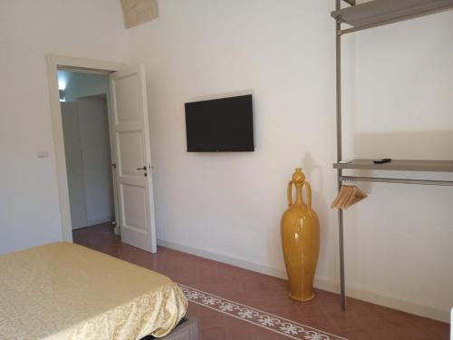 a room with a bed and a tv on a wall at Civico 17 in Lecce
