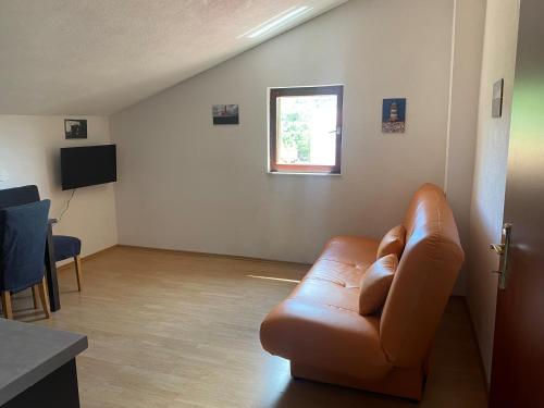 a living room with a leather couch and a window at Villa Una Apartments in Labin