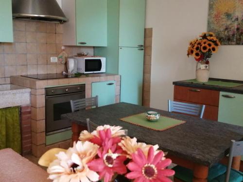 - une cuisine avec une table et des fleurs dans l'établissement Il Casaletto, à Acquasparta