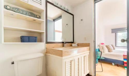 een badkamer met een wastafel, een spiegel en een bed bij Marmaris Apartment in Cancun