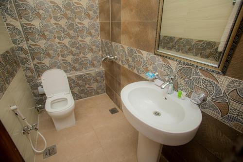 a bathroom with a sink and a toilet at Hotel white season Gulberg in Lahore