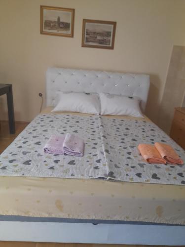 un letto con due asciugamani e due cuscini sopra di For you apartman a Niš