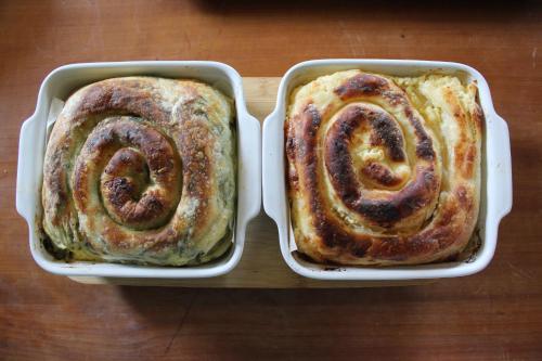 two rolls in white trays on a wooden table at Chechar Inn Zlatar in Nova Varoš