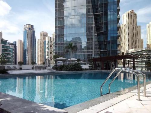 a large swimming pool in a city with tall buildings at LUX Holiday Home Dubai Marina JBR - Silverene Tower Studios in Dubai