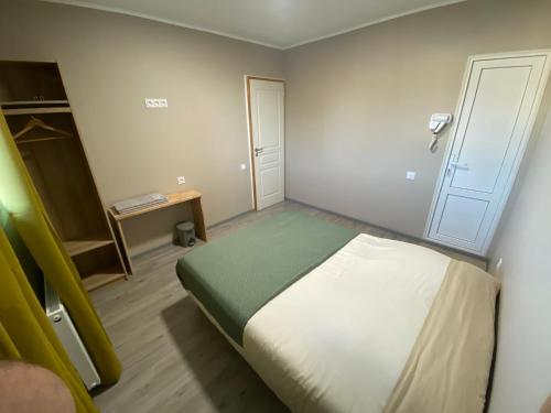 Habitación pequeña con cama y puerta en Maison OK riba Aéroport Mérignac, en Mérignac
