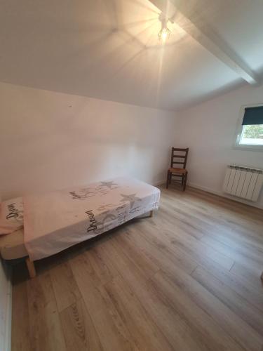 een slaapkamer met een bed en een stoel in een kamer bij Appartement F4 Le Milena in Saint-Paul-et-Valmalle
