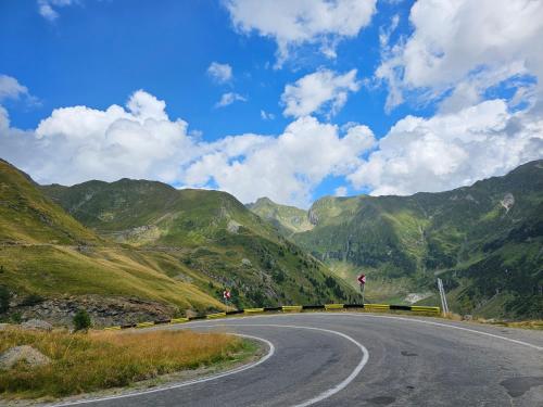 an empty road with mountains in the background at Casa Oaspeti Transfagarasan in Cîrţişoara