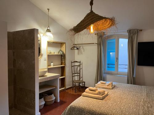 a bedroom with a bed and a sink and a mirror at La Recampado in Bormes-les-Mimosas
