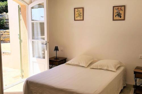 een slaapkamer met een wit bed en een open deur bij Maison Les Marres St-Tropez / Ramatuelle in Saint-Tropez