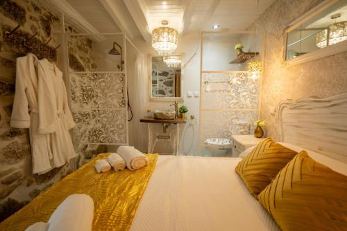 1 dormitorio con 1 cama grande y baño en Casinhas do Miga en Santa Comba Dão