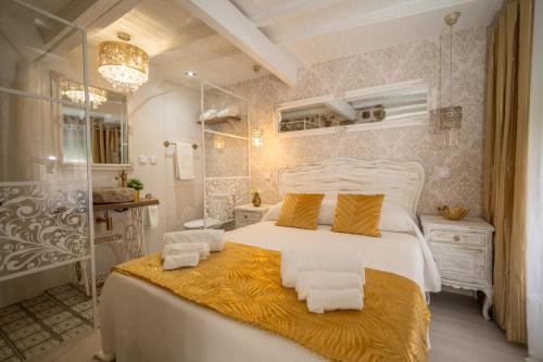 a bedroom with a large white bed and a bathroom at Casinhas do Miga in Santa Comba Dão