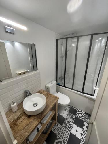 La salle de bains est pourvue d'un lavabo blanc et de toilettes. dans l'établissement Les cottages chambre privée chez l habitant, à Saint-Malo