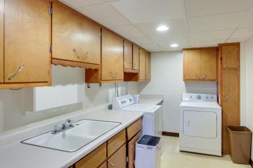 a kitchen with a sink and a washer and dryer at Retro Green Bay Home Steps to Lambeau Field! in Green Bay