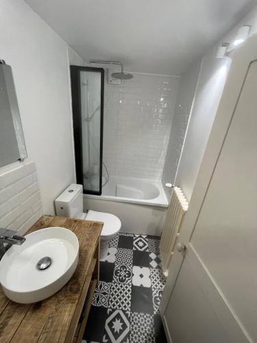 La salle de bains est pourvue de toilettes, d'un lavabo et d'une baignoire. dans l'établissement Les cottages chambre privée chez l habitant, à Saint-Malo