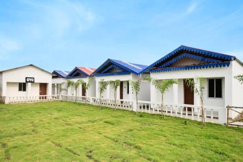 a row of houses with palm trees in the yard at Hotel O Mango Leaf Hotel & Restaurant in Baharampur