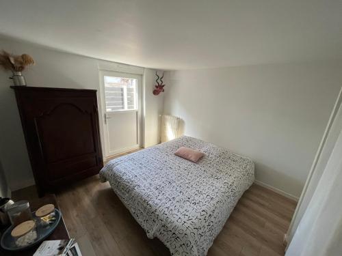 niewielka sypialnia z łóżkiem i oknem w obiekcie Les cottages chambre privée chez l habitant w Saint-Malo