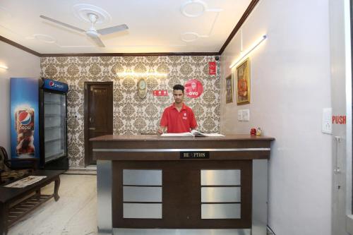 un homme debout derrière un bar dans une pièce dans l'établissement OYO Flagship Hotel Sangam 45, à Chandigarh