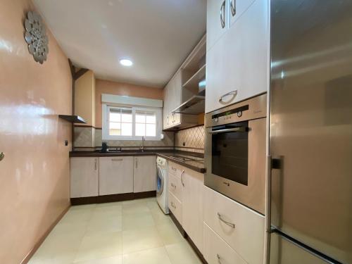 a kitchen with a stove and a refrigerator at Apartamento Calle Galaroza in Huelva