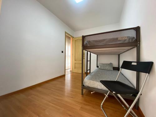 a bedroom with a bunk bed and a chair at Apartamento Calle Galaroza in Huelva