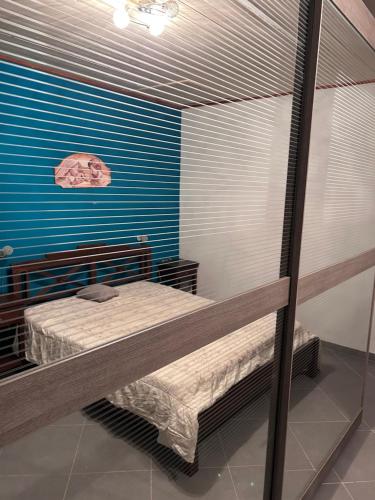 Zimmer mit 2 Etagenbetten und einer blauen Wand in der Unterkunft Casa vacanza I Pavoni in Campanedda