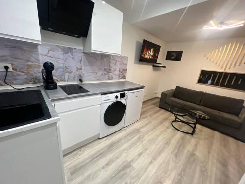 een keuken en een woonkamer met een bank bij Maison Appartement Triplex avec jacuzzi et sauna in Saint-Étienne