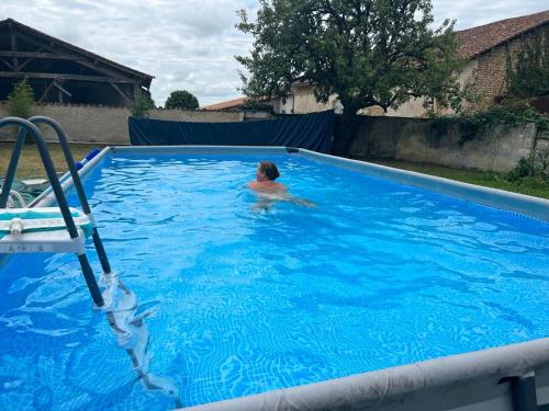 un homme nageant dans une piscine dans l'établissement Le Loriot, à Champagne-et-Fontaine