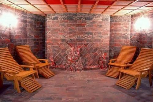 a room with chairs and a brick wall with a fireplace at Olimpija Hotel & SPA in Daugavpils