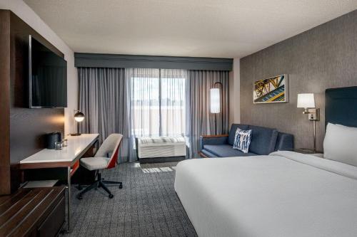 um quarto de hotel com uma cama e uma secretária e uma cama e uma secretária em Courtyard by Marriott Boston Billerica Bedford em Billerica