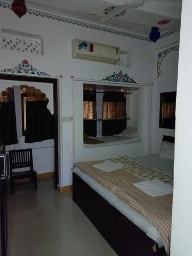 a bedroom with a bed and a chair in it at The Royal Lake View Villa in Udaipur