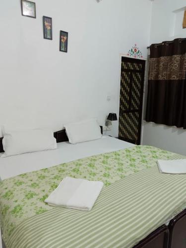 a bedroom with two beds with green sheets at The Royal Lake View Villa in Udaipur