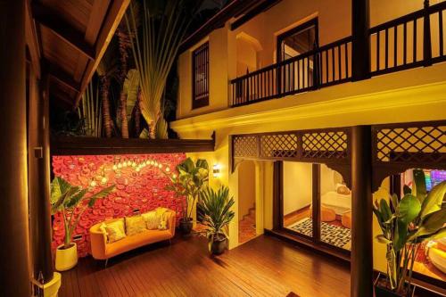 een woonkamer met een gele bank en een rode muur bij 曼谷夏日马卡龙别墅民宿 in Bangkok