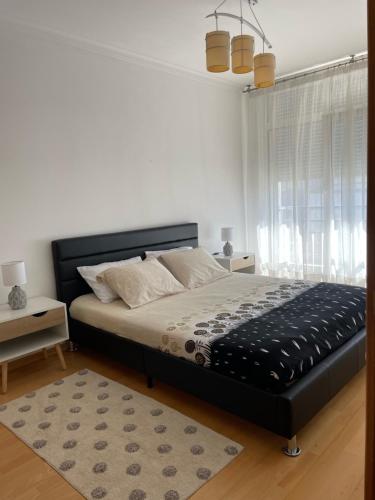 a bedroom with a bed with a black headboard and a rug at Appartement T1 Centre Pombal in Pombal