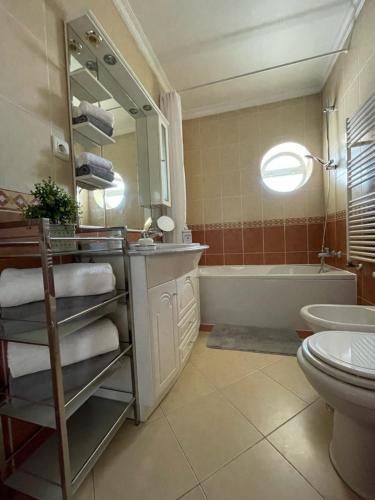 a bathroom with a sink and a tub and a mirror at Appartement T1 Centre Pombal in Pombal