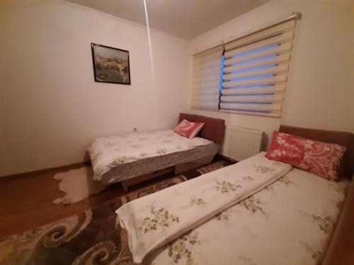 een kamer met 2 bedden en een raam bij APARTMAN ILIDZA- KUCA DVA SPRATA in Ilidza