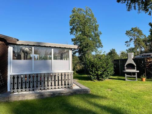 una pequeña casa con una valla en un patio en CASALINO DI ANNA, en Wensickendorf