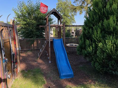 a playground with a blue slide in a yard at CASALINO DI ANNA in Wensickendorf