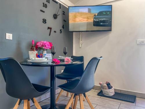 a table with chairs and a tv on a wall at Apartment Sova or Deluxe room 33 in Bled