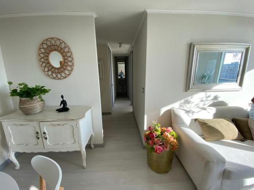 a living room with a white couch and a table at Lindo departamento vista al mar in Coquimbo